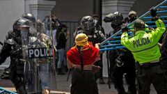 Police remove a barrier dismantled by protesters demonstrating against lower wages and budget cuts imposed by the government amid the new coronavirus pandemic in downtown Quito, on May 25, 2020. (Photo by Cristina Vega Rhor / AFP)