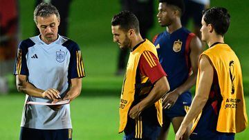 Spain's coach Luis Enrique (L) talks with players during a training session at the Qatar University training ground in Doha on November 30, 2022, on the eve of the Qatar 2022 World Cup football match between Japan and Spain. (Photo by JAVIER SORIANO / AFP)