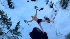 Ken Stornes saltando con dos hachas en la disciplina death diving o dodsing, en un lago con nieve.