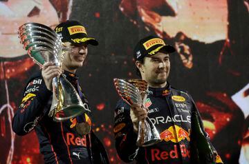 Max Verstappen con el trofeo en el podio después de ganar el Gran Premio de Abu Dhabi junto al tercer clasificado Sergio Pérez su compañero en Red Bull.