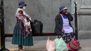 01/06/2020 01 June 2020, Bolivia, La Paz: Two women with face masks wait for the bus at a bus stop amid the relaxations of restrictions that were put into effect to curb the spreading of coronavirus. Photo: Alexis-Demarco/ABI/dpa SOCIEDAD INTERNACIONAL Alexis-Demarco/ABI/dpa