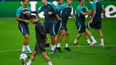 Xavi controla el balón mientras los jugadores hacen ejercicios sobre el césped del estadio portugués.