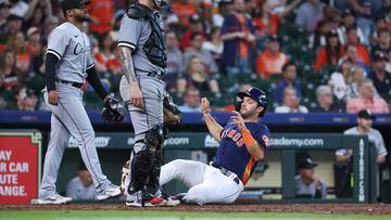 Apr 2, 2023; Houston, Texas, USA; Houston Astros catcher Cesar Salazar (18) slides to score a run as Chicago White Sox relief pitcher Reynaldo Lopez (40) and catcher Yasmani Grandal (24) look on during the ninth inning at Minute Maid Park. Mandatory Credit: Troy Taormina-USA TODAY Sports