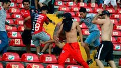 Supporters of Atlas fight with supporters of Queretaro during the Mexican Clausura tournament football match between Queretaro and Atlas at Corregidora stadium in Queretaro, Mexico on March 5, 2022. -