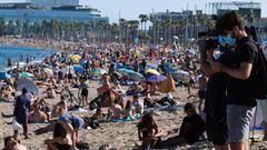 Journalists record as people enjoy the sunny weather at the Barceloneta beach, after Catalonia&#039;s regional authorities and the city council announced restrictions to contain the spread of the coronavirus disease (COVID-19) in Barcelona, Spain July 19,
