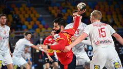 Spain&#039;s pivot Ruben Marchan Criado (C) attempts a shot as he is challenged by Denmark&#039;s pivot Magnus Saugstrup (R) during the 2021 World Men&#039;s Handball Championship semifinal match between Spain and Denmark at the Cairo Stadium Sports Hall 