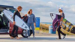 Los surfistas Alex Vilalta, Luc&iacute;a Marti&ntilde;o e &Iacute;talo Ferreira se saludan frente a una furgoneta en la playa de Castelldefels (Barcelona) en octubre del 2021 durante el rodaje del documental Barcelona Surf Destination producido por Surf C