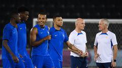 France's coach Didier Deschamps (R) and France's assistant coach Guy Stephan (2nd R) speak together as (from L) France's forward Ousmane Dembele, France's midfielder Aurelien Tchouameni, France's defender Jules Kounde and France's forward Kylian Mbappe walk past them during a training session at the Al Sadd SC training center in Doha, on December 3, 2022, on the eve of the Qatar 2022 World Cup round of 16 football match between France and Poland. (Photo by FRANCK FIFE / AFP)