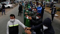 People wearing face masks wait in line next to oxygen tanks outside a private distributor that recharges tanks, amid the spread of the coronavirus disease (COVID-19), in Lima, Peru June 25, 2020. REUTERS/Sebastian Castaneda NO RESALES. NO ARCHIVES