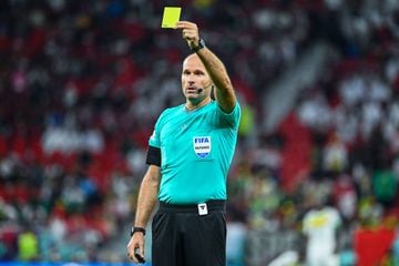 Referee Antonio Mateu Lahoz shows a yellow card during Senegal's 3-1 group-stage win over Qatar.
