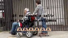 Una abuela pasenado sobre una tabla de skate a un abuelo en silla de ruedas, en Talcahuano (Chile).