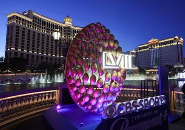 The Fountains of Bellagio launch behind a display of footballs with a Super Bowl LVIII logo on the CBS Sports set.