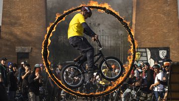Un ciclista realiza un espectacular y arriesgado ejercicio, pasando por un aro envuelto en llamas sobre su bicicleta, ante la atenta mirada de un grupo de aficionados que quiso inmortalizar el momento con sus teléfonos móviles. La exhibición tuvo lugar durante la celebración del día del BMX en Santiago de Chile.