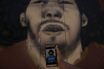 Graffiti artist Angelo Campos uses his cell phone to paint a mural of Argentine soccer legend Diego Maradona at the Vila Cruzeiro slum in Rio de Janeiro, Brazil, November 26, 2020. REUTERS/Pilar Olivares