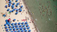 CATANIA, ITALY - AUGUST 15: Aerial view of a beach on the Catania coast, the Playa, among beach umbrellas and people in the sea on August 15, 2022 in Catania, Italy. 15 August is traditionally spent at the seaside in Sicily by thousands of families. This year, the island, especially the east coast of Sicily, was visited by thousands of tourists who sold out restaurants and hotels. (Photo by Fabrizio Villa/Getty Images)