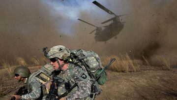 US soldiers scramble to avoid the landing zone of a Chinook helicopter