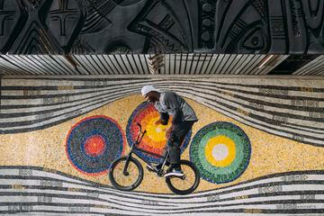 Courage Adams realiza un truco encima de su bicicleta delante de un mural en Lagos (Nigeria)