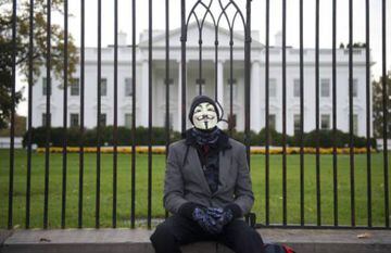 Un miembro o simpatizante del grupo Anonymous posa frente a la Casa Blanca