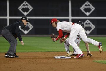 Arizona Diamondbacks Corbin Carroll (Back) slides safely into second base while beating the tag by Philadelphia Phillies second baseman Bryson Stott (Front) on a steal as umpire Dan Iassogna (L) eyes the play during the third inning of game seven of the Major League Baseball (MLB) National League Championship Series. 