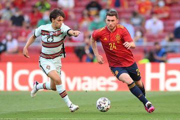 Joao Felix of Portugal challenges Aymeric Laporte of Spain.