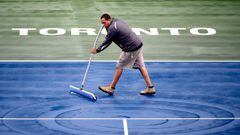 Un trabajador del estadio donde se disputa el torneo de tenis Rogers Cup de Toronto se afana en quitar el agua de la lluvia caída en la pista central. 