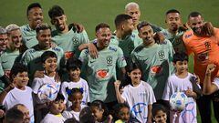 Los jugadores de Brasil posan con un grupo de niños en Doha.