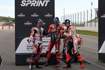 Francesco Bagnaia, Jorge Martin y Marc Márquez celebran en el podio brindando con las botellas de champán.