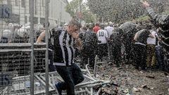 A man runs as Turkish anti-riot police use tear gas and water cannon to disperse supporters around the stadium before the Turkish Spor Toto Super league football match between Besiktas and Bursaspor at vodafone arena stadium on April 11, 2016