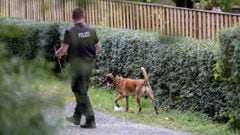 28 July 2020, Lower Saxony, Seelze: A police officer with a dog searches an area inside a garden as part of an investigation plan to find any clues about the disappearance of the British girl Madeleine McCann on 3 May 2007. Photo: Peter Steffen/dpa - ACHT