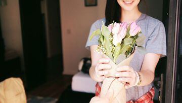 Imagen de una chica recibiendo un ramo de flores.