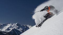 El esquiador Aymar Navarro esquiando sobre nieve virgen en Baqueira Beret (Val d&#039;Aran, Lleida, Catalunya, Espa&ntilde;a) con las monta&ntilde;as al fondo. 