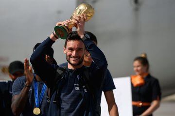 France's goalkeeper Hugo Lloris smiles as he holds the trophy as he celebrates with teammates upon their arrival at the Roissy-Charles de Gaulle airport on the outskirts of Paris, on July 16, 2018 after winning the Russia 2018 World Cup final football mat