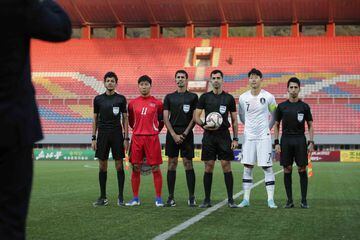 Son Heung-min, capitán de Corea del Sur; y Jong Il-Gwan, capitán de Corea del Norte, posan junto a los árbitros del encuentro.