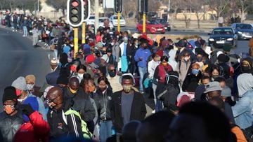 Stranded commuters wait for transportation at a bus terminal during a protest by taxi operators over the government&#039;s financial relief for the taxi industry, amid the coronavirus disease (COVID-19) lockdown, in Soweto, South Africa, June 22, 2020. RE