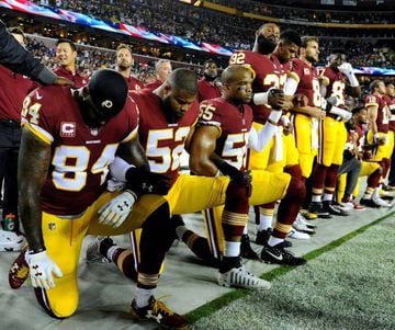 Washington Redskins tight end Niles Paul and linebacker Ryan Anderson and Washington Redskins linebacker Chris Carter kneel with teammates