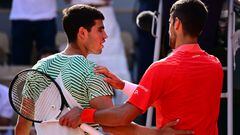 Serbia's Novak Djokovic (R) comforts Spain's Carlos Alcaraz Garfia after his victory during their men's singles semi-final match on day thirteen of the Roland-Garros Open tennis tournament at the Court Philippe-Chatrier in Paris on June 9, 2023. (Photo by Emmanuel DUNAND / AFP)