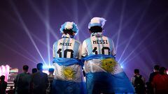 Dos seguidores de Lionel Messi observan la ceremonia inaugural del Mundial de Qatar 2022.