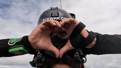 Nathy Odinson haciendo un corazón con las manos durante un salto en paracaídas.