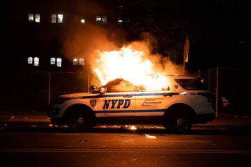 A NYPD police car is set on fire as protesters clash with police during a march against the death in Minneapolis police custody of George Floyd, in the Brooklyn borough of New York City, U.S., May 30, 2020. Picture taken May 30, 2020. REUTERS/Jeenah Moon 