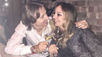 Luka Modric con su mujer, Vanja Bosnic, cogidos y muy sonrientes al brindar con una copa.