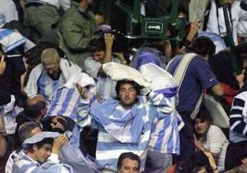 Los hinchas argentinos tuvieron que protegerse de las sillas que les lanzaban.