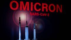 (FILES) This file photo taken in Toulouse, southwestern France, on December 1, 2021 shows syringes and a screen displaying Omicron, the name of the new covid 19 variant. - Omicron has become the main coronavirus strain in France where the number of infect