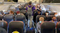 (FILES) In this file photo taken on May 3, 2020 passengers, almost all wearing facemasks, board an American Airlines flight to Charlotte, in New York City. - Wearing masks to prevent the spread of the coronavirus was not widespread in March, when a group 