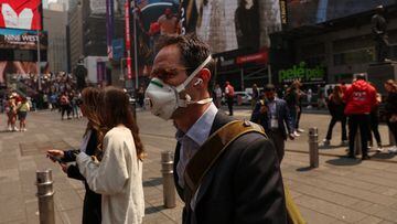 A man wears a protective face mask walking through Times Square during warnings by officials of heavy pollution after thick haze and smoke caused by wildfires in Canada covered the area, in New York City, U.S., June 8, 2023. REUTERS/Shannon Stapleton