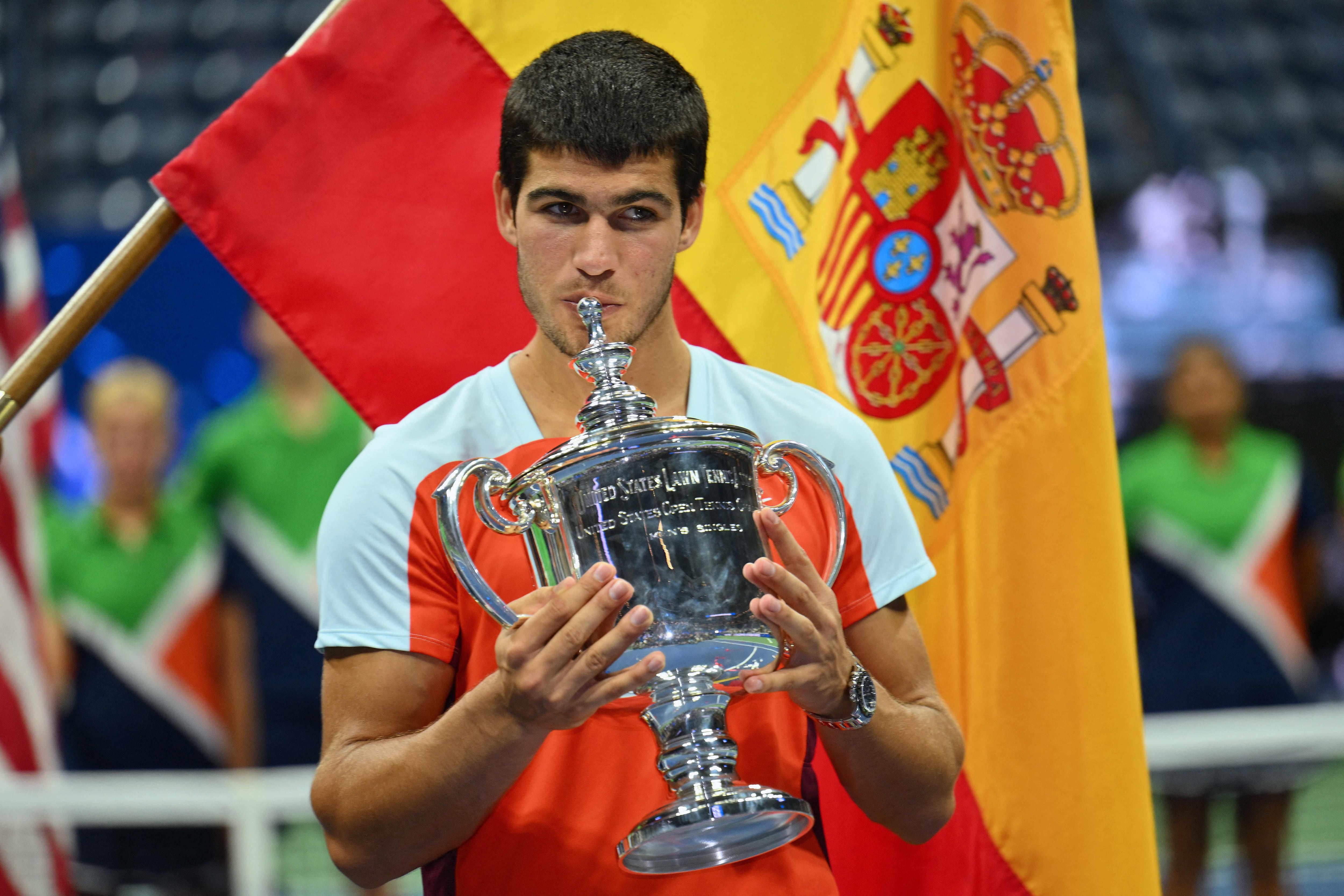 (FILES) In this file photo taken on September 12, 2022 Spain's Carlos Alcaraz celebrates with the trophy after winning against Norway's Casper Ruud during their 2022 US Open Tennis tournament men's singles final match at the USTA Billie Jean King National Tennis Center in New York. - Carlos Alcaraz wins the US Open and becomes the youngest ever world number one at 19. (Photo by ANGELA WEISS / AFP)