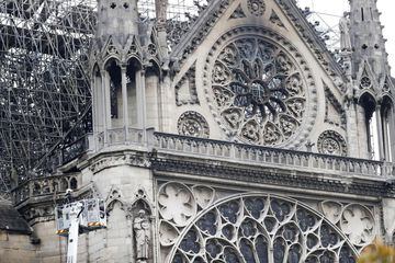  Un bombero trabaja en un elevador junto al andamiaje que cubre parte de la catedral de Notre Dame