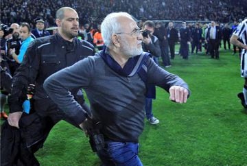 Russian-born Greek businessman and owner of PAOK Salonika, Ivan Savvides (C), pictured with what appears to be a gun in a holster, enters the pitch after the referee annulled a goal of PAOK during their soccer match against AEK Athens in Toumba Stadium in