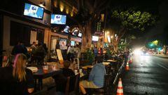 People view a television broadcast of Game 1 of the 2020 World Series between the Los Angeles Dodgers and the Tampa Bay Rays at an outdoor bar and restaurant, with seating on the street due to COVID-19, on October 20, 2020 in Los Angeles, California.
