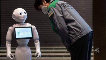 Tokyo Governor Yuriko Koike (R) looks at a greeting robot called &quot;Pepper&quot; (L) as she visits a hotel during the first day the building is used as a new medical lodging facility to accommodate COVID-19 coronavirus patients with mild symptoms in To
