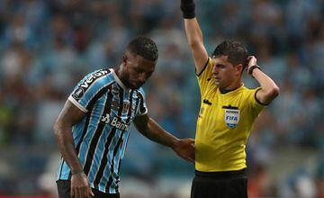 Gremio's Paulo Miranda is shown a yellow card by referee Andres Cunha.